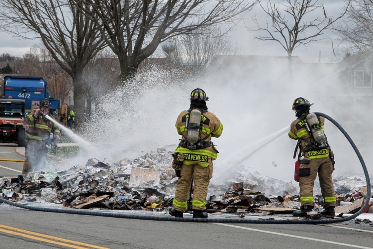 Fire fighters work on putting out the recycling fire